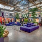 The interior of a warehouse with purple couches and plants.
