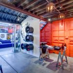 A garage with an orange door and a tire rack.